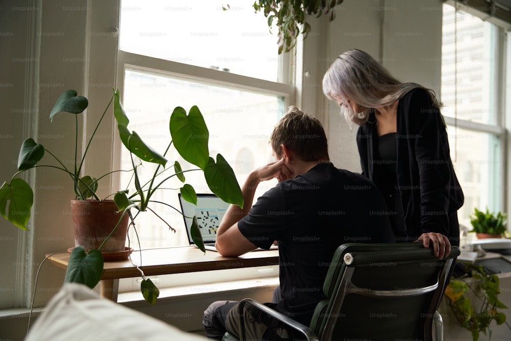 Un uomo e una donna seduti a un tavolo che guardano un computer portatile
