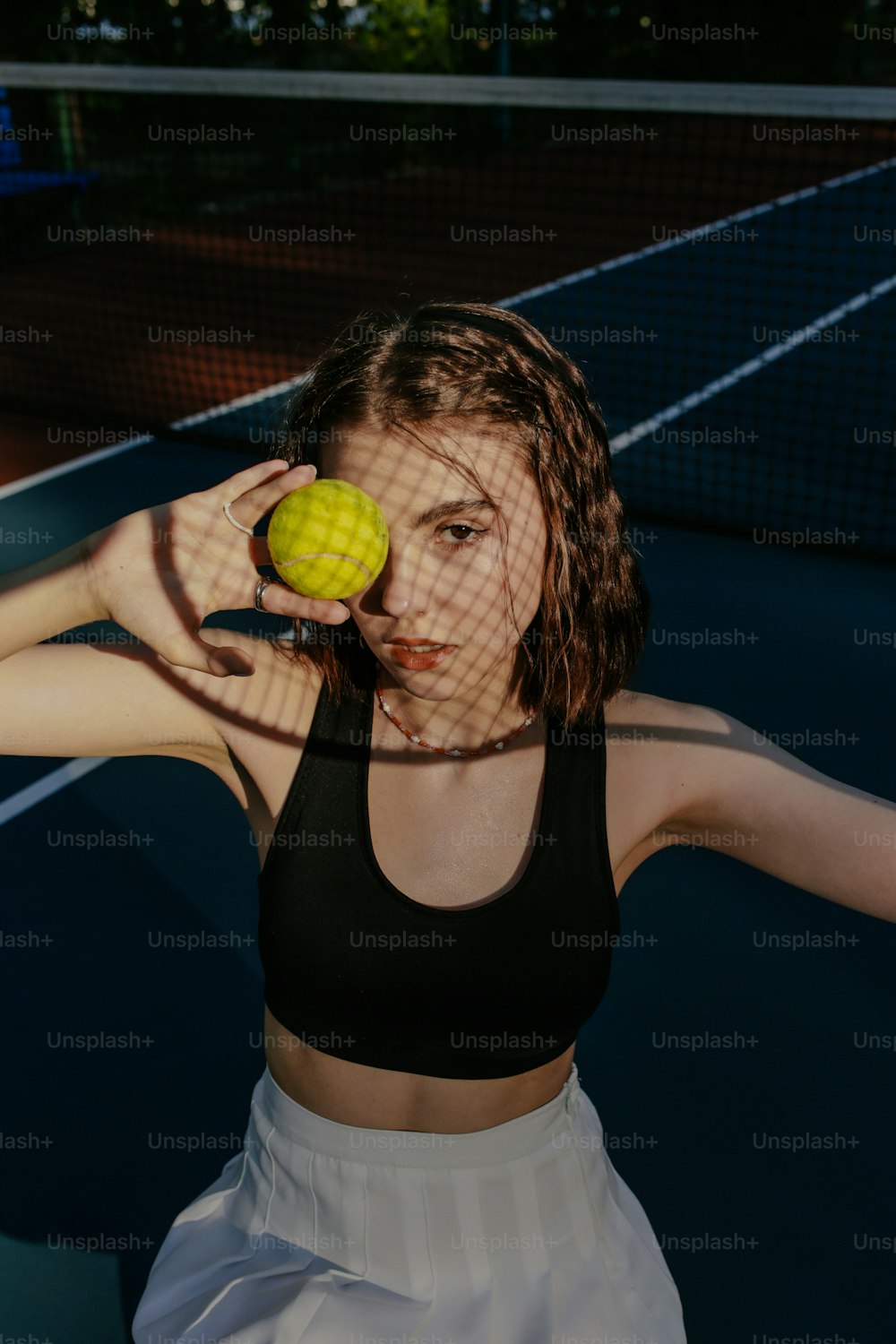 Una mujer sosteniendo una pelota de tenis y una raqueta de tenis