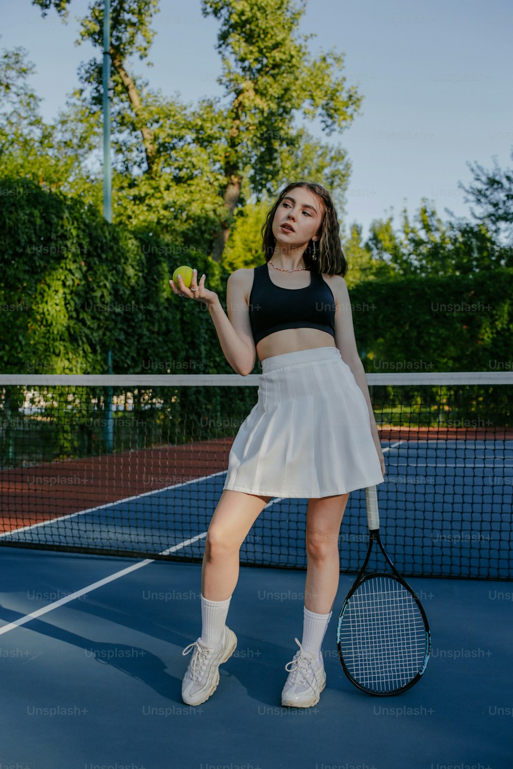 Una mujer sosteniendo una raqueta de tenis en una cancha de tenis