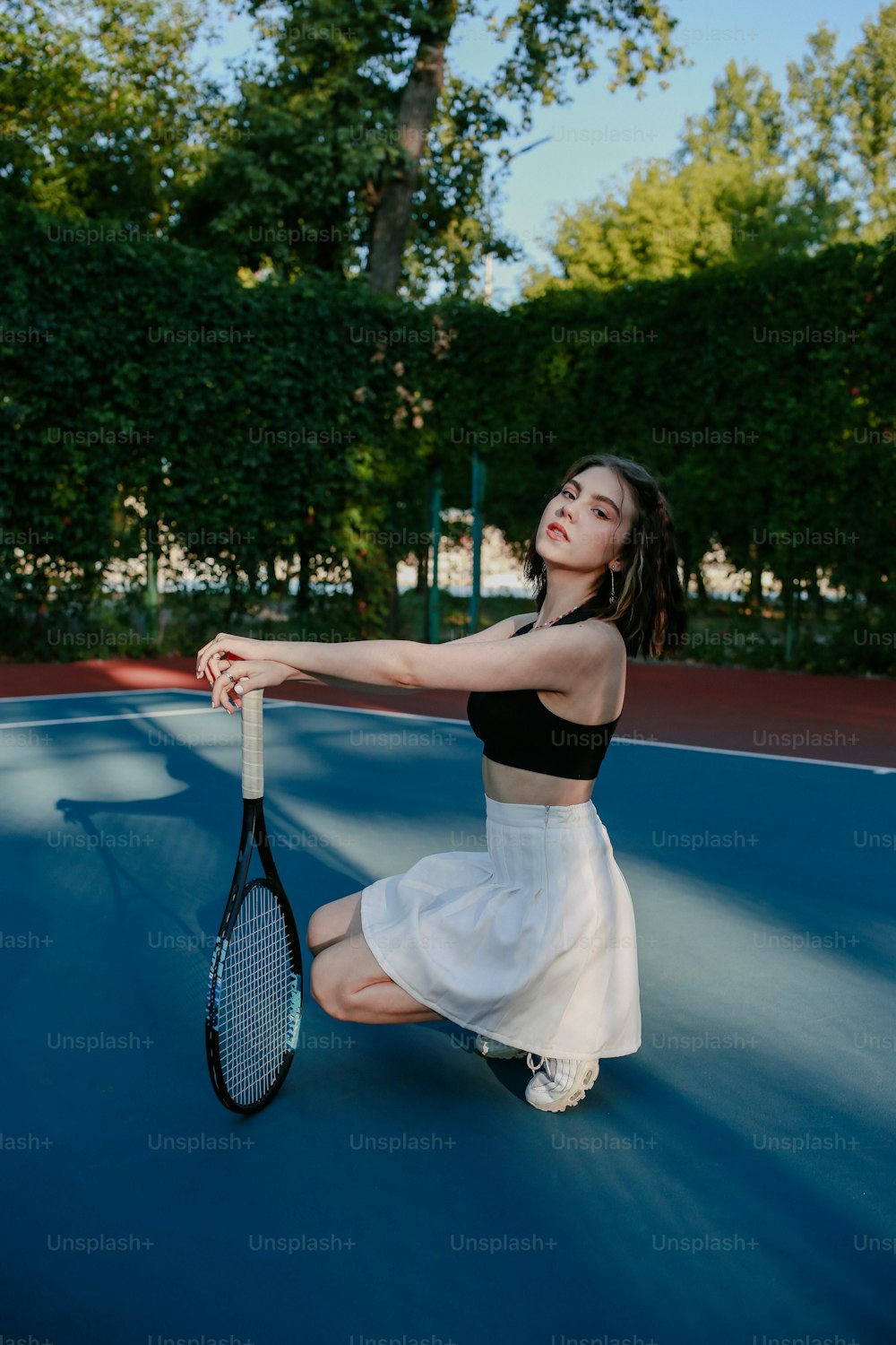 テニスコートでテニスラケットを持つ若い女性
