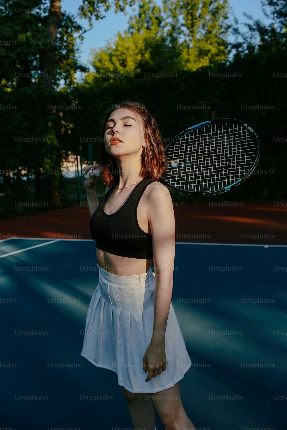 uma mulher em pé em uma quadra de tênis segurando uma raquete