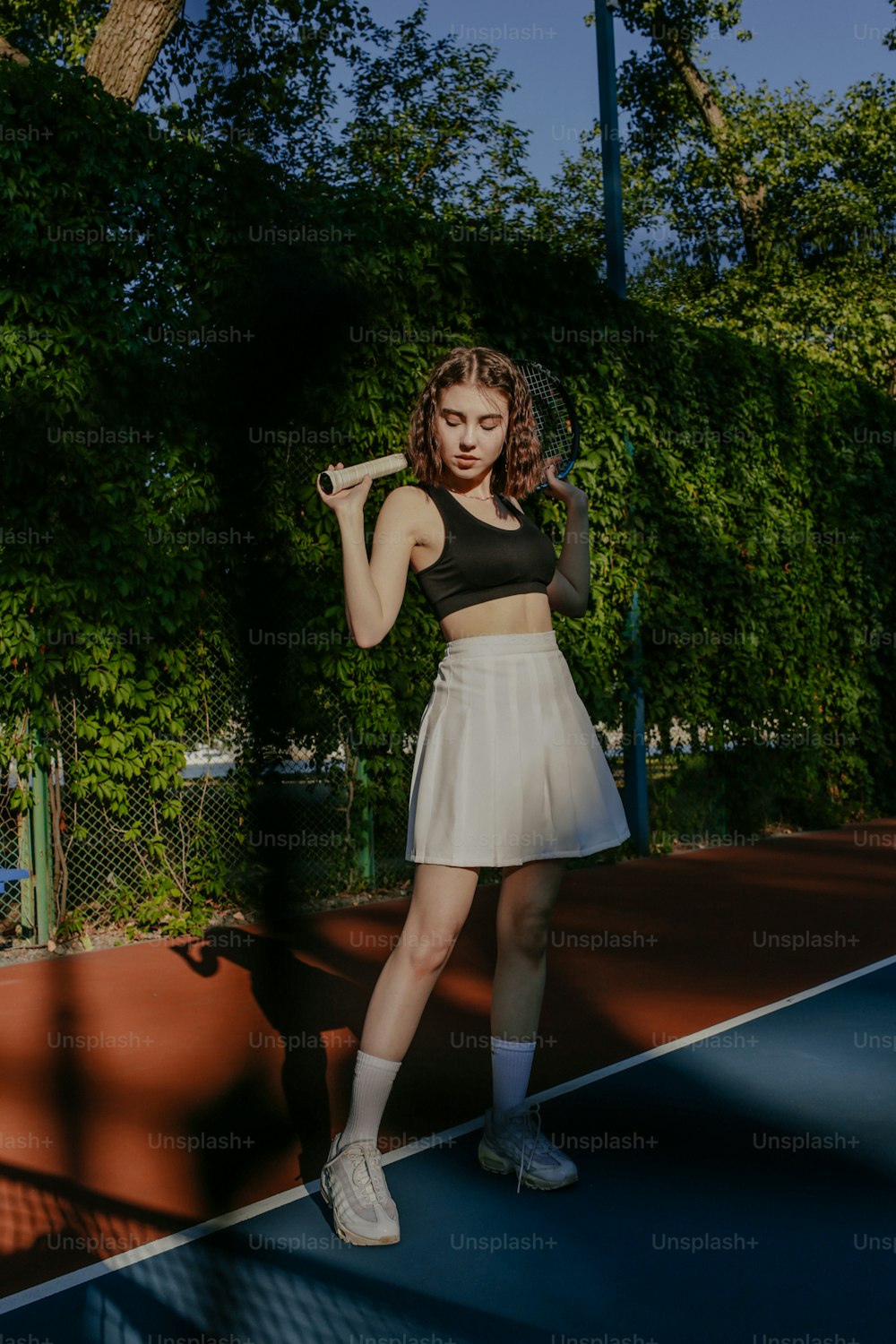 Una mujer parada en una cancha de tenis sosteniendo una raqueta