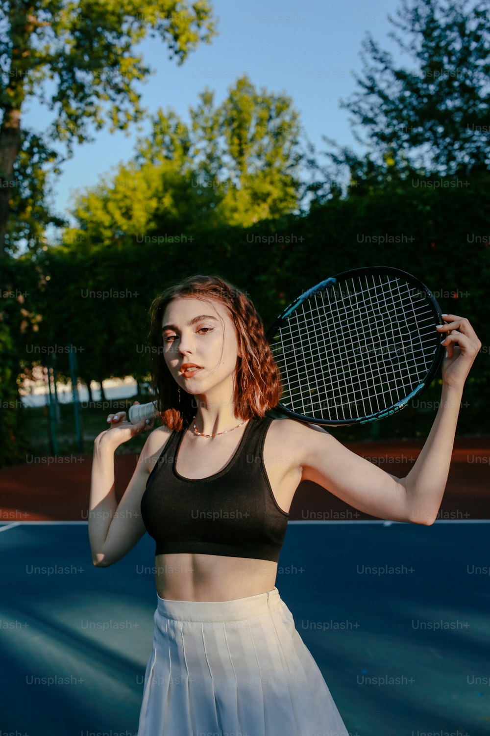 テニスコートの上にテニスラケットを持�つ女性