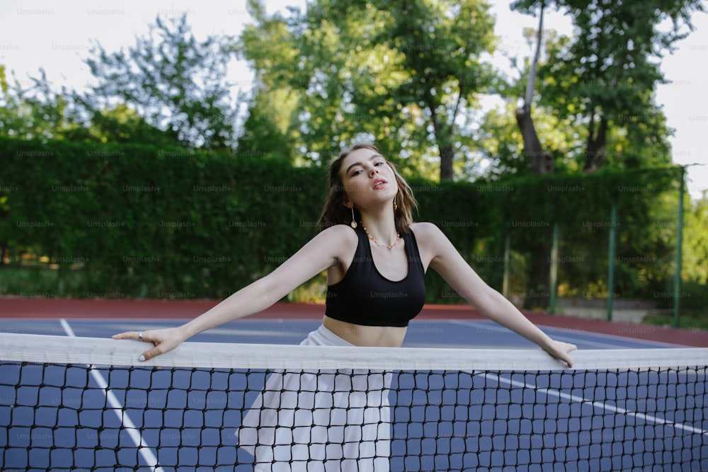 Una mujer parada en una cancha de tenis sosteniendo una raqueta de tenis