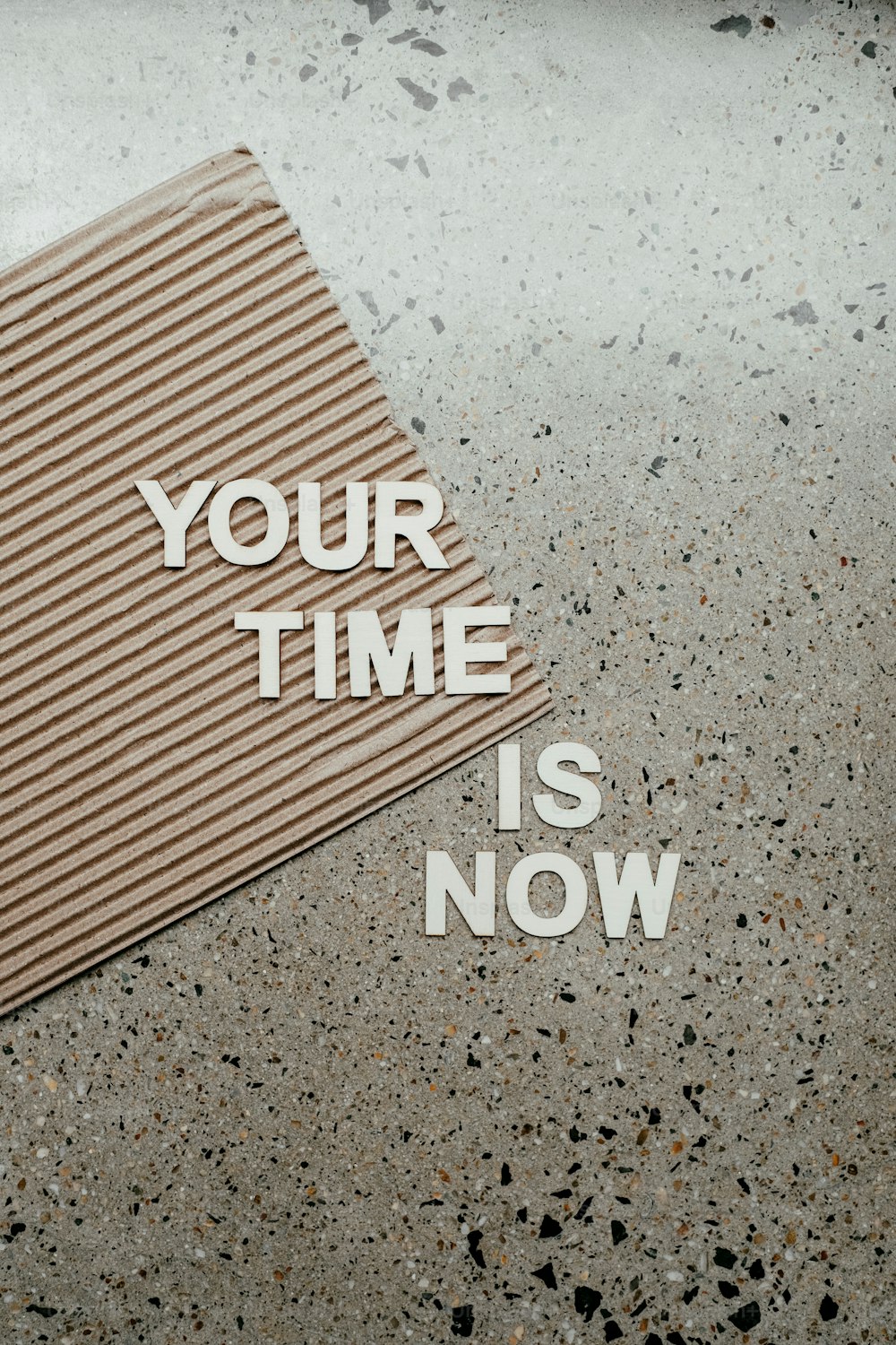 a piece of cardboard with the words your time is now written on it