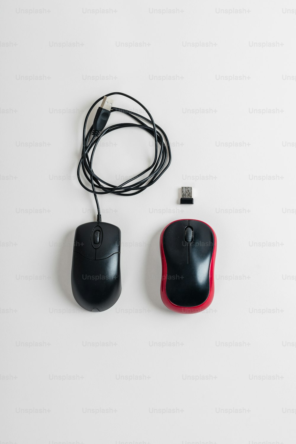 a black and red computer mouse next to a usb mouse