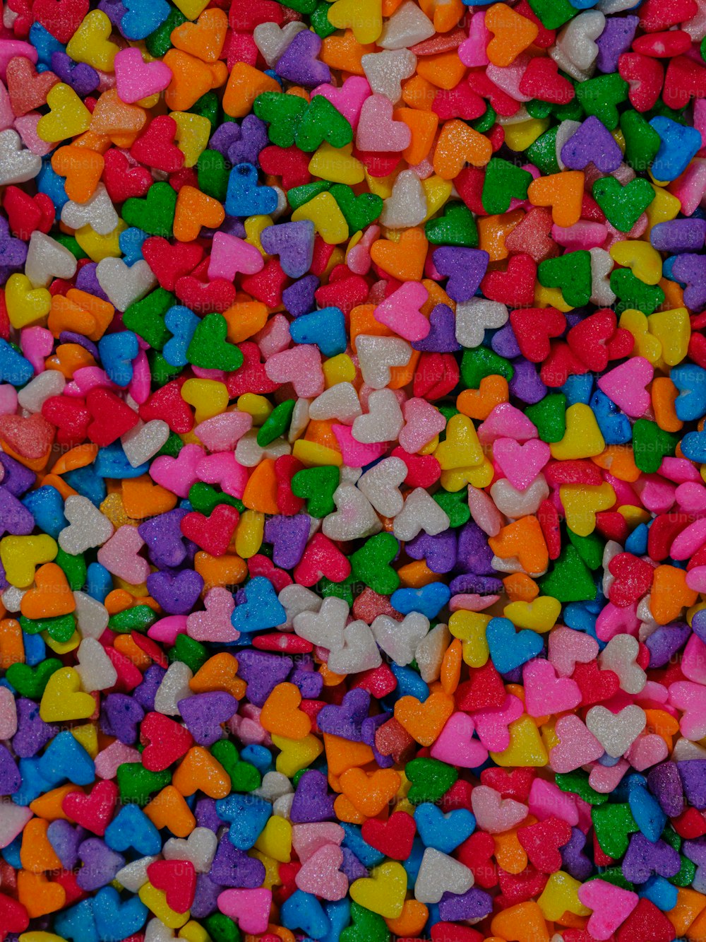 a pile of heart shaped candies sitting on top of a table