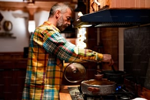 a man in a plaid shirt is cooking in a kitchen