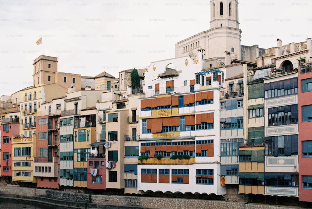 a row of multi - colored buildings next to a body of water