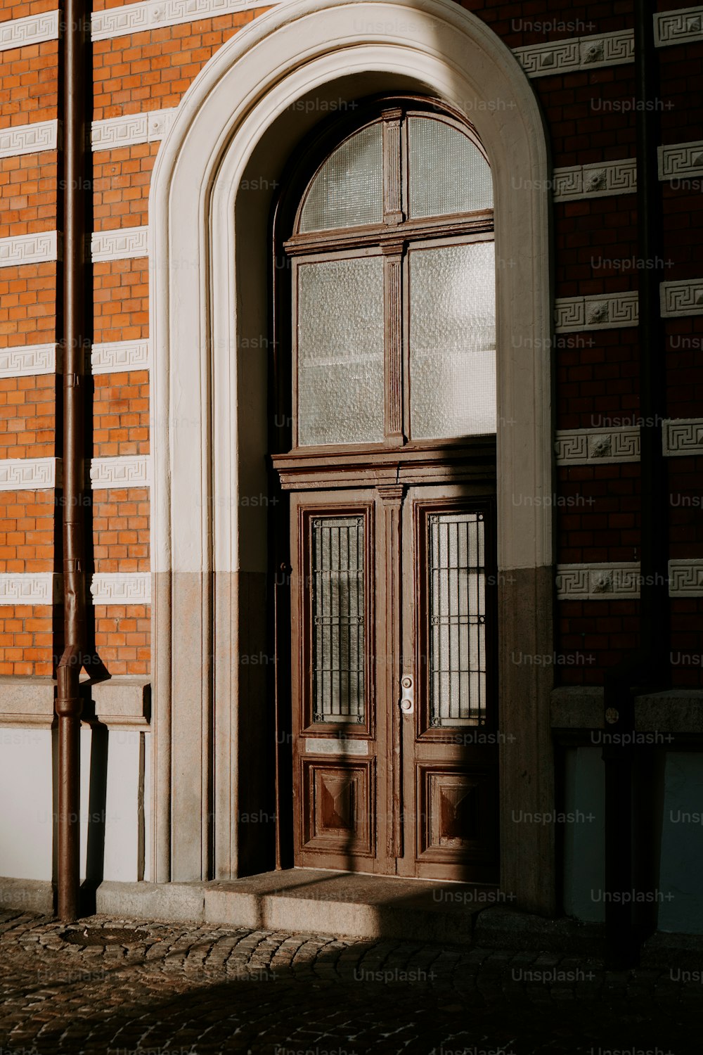 a building with a large wooden door and arched window