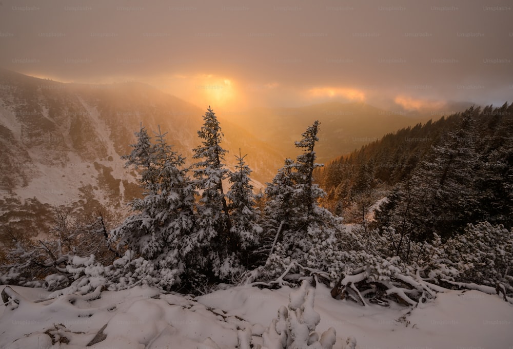 Il sole splende tra le nuvole sopra le montagne