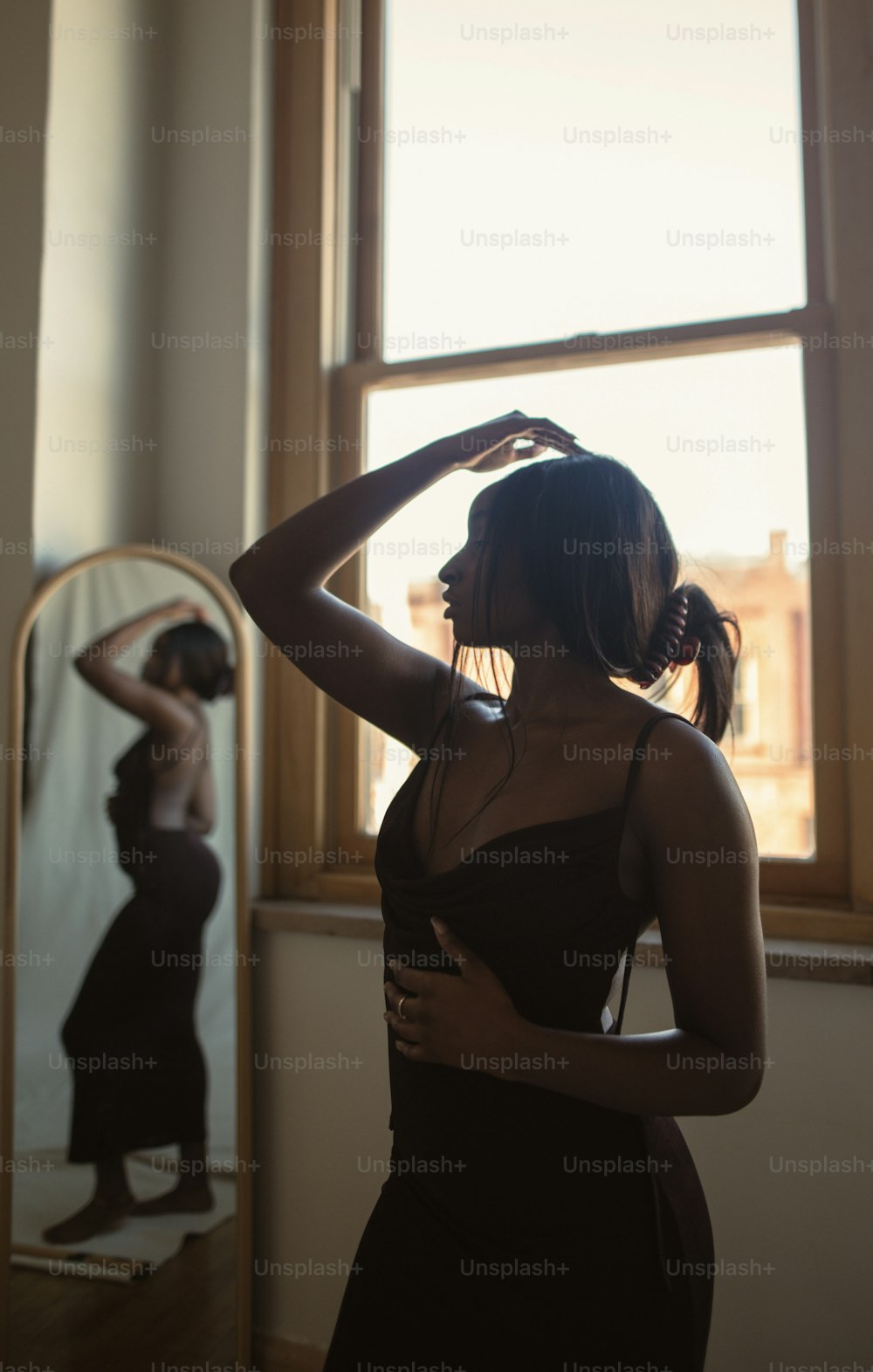 uma mulher em pé na frente de um espelho