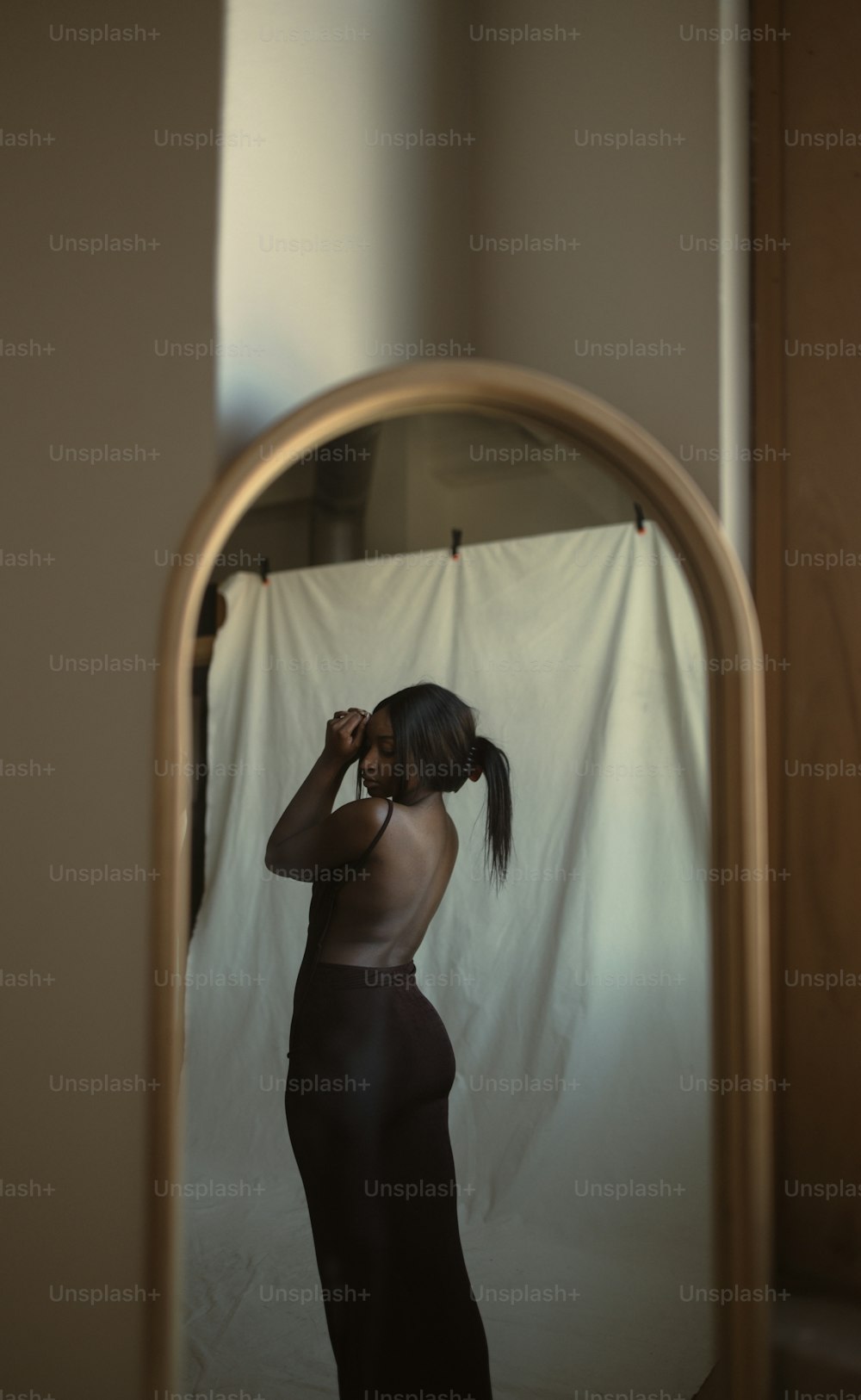 Eine Frau, die vor einem Spiegel steht und sich die Haare bürstet