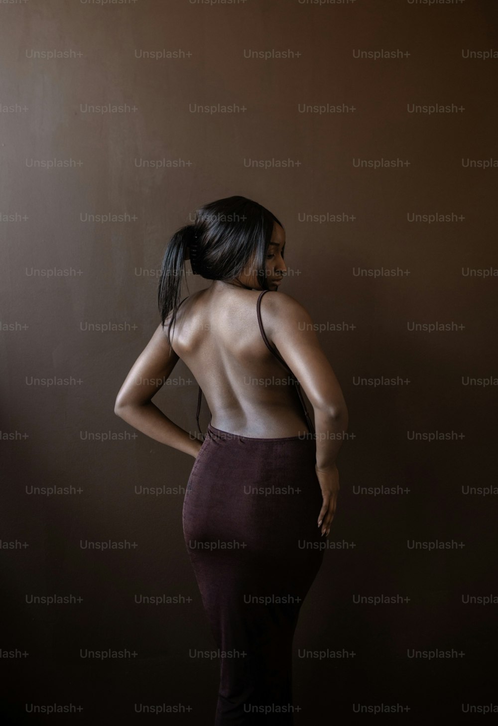 a woman standing in a dark room with her back to the camera