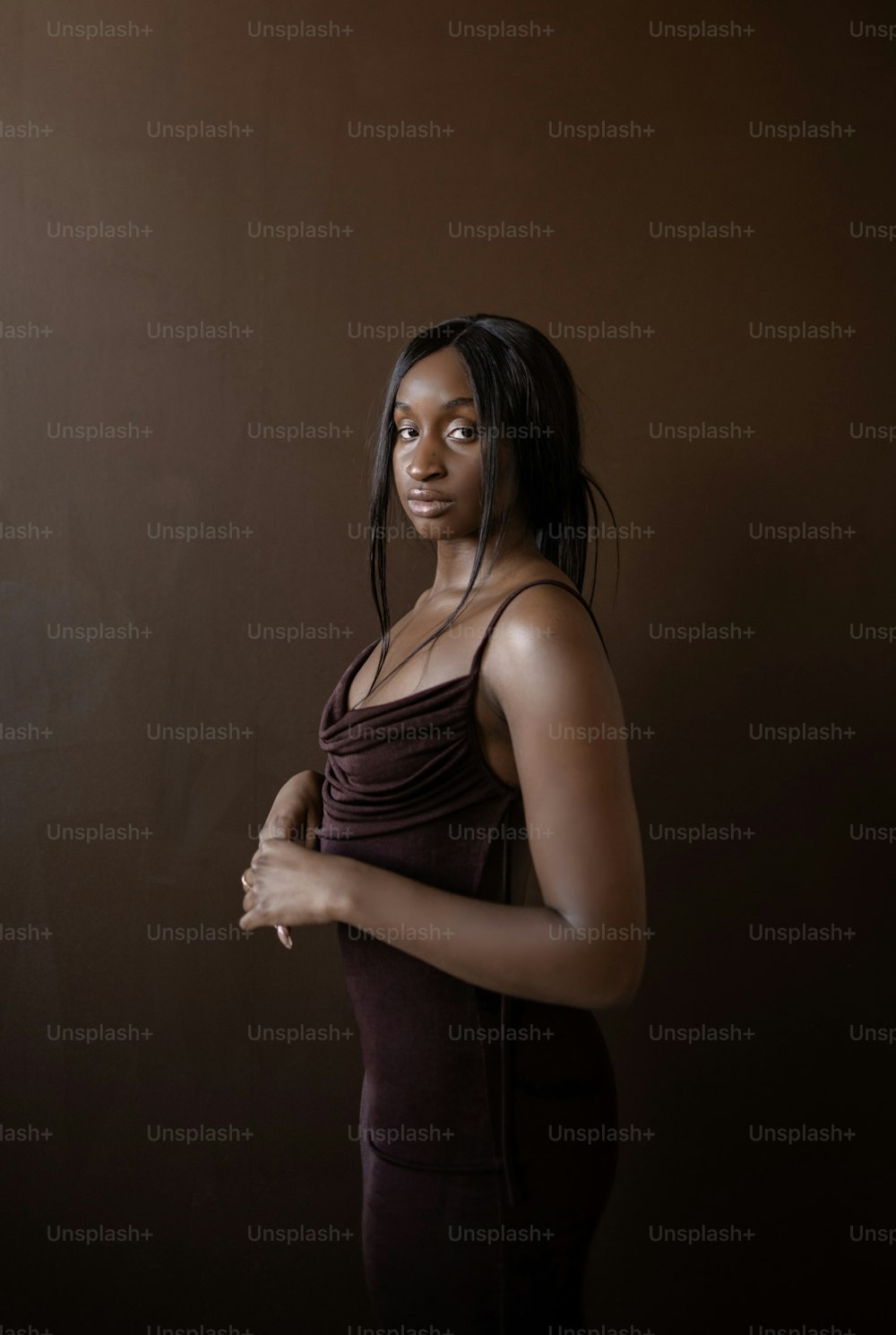 Eine Frau in einem braunen Kleid posiert für ein Foto