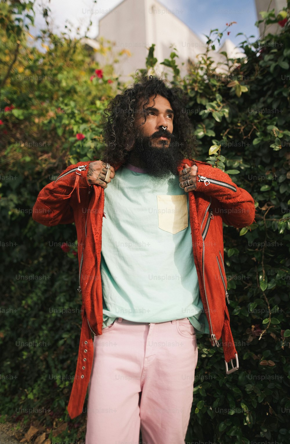 a man with long hair and a beard wearing pink pants