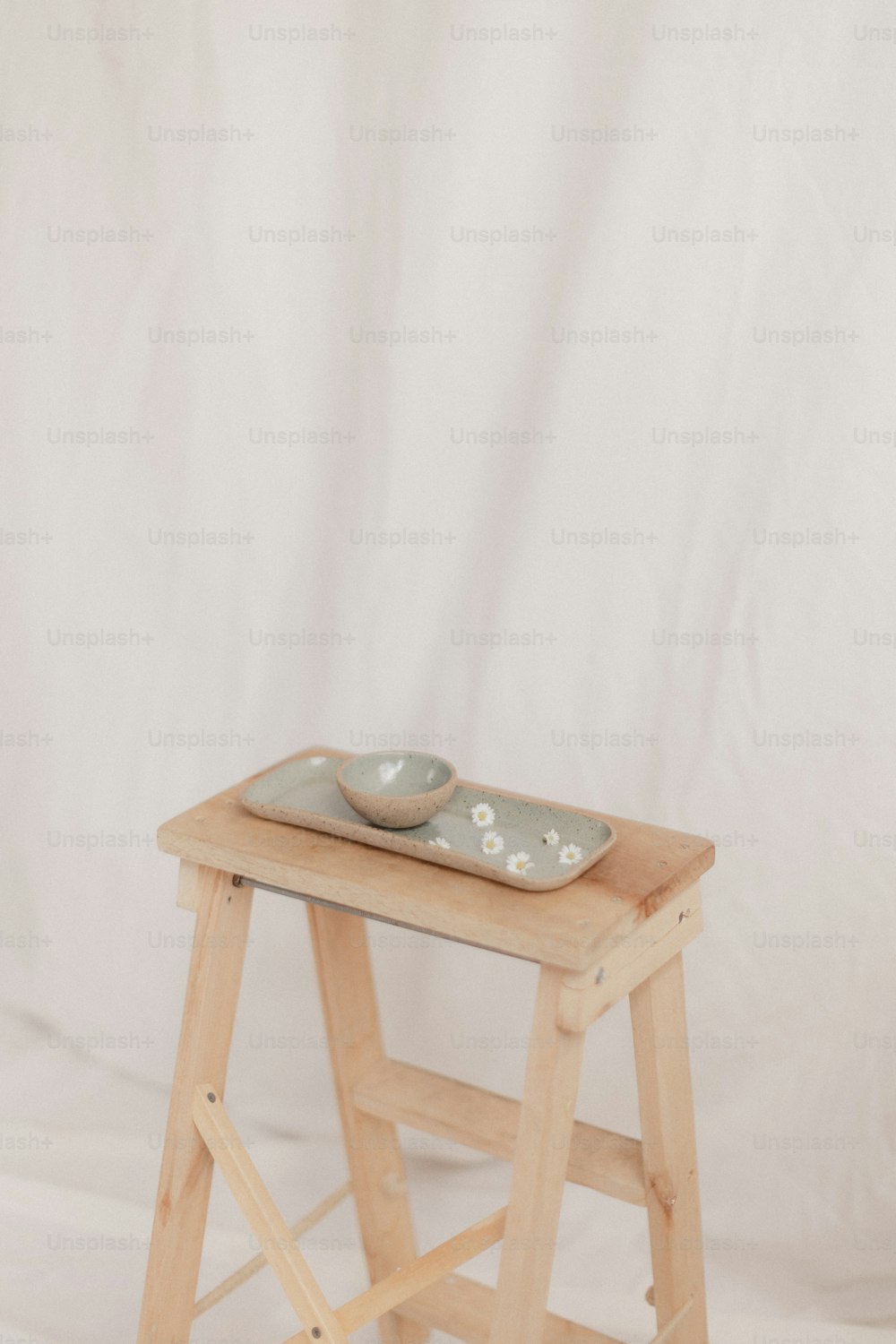 a wooden stool with a bowl on top of it