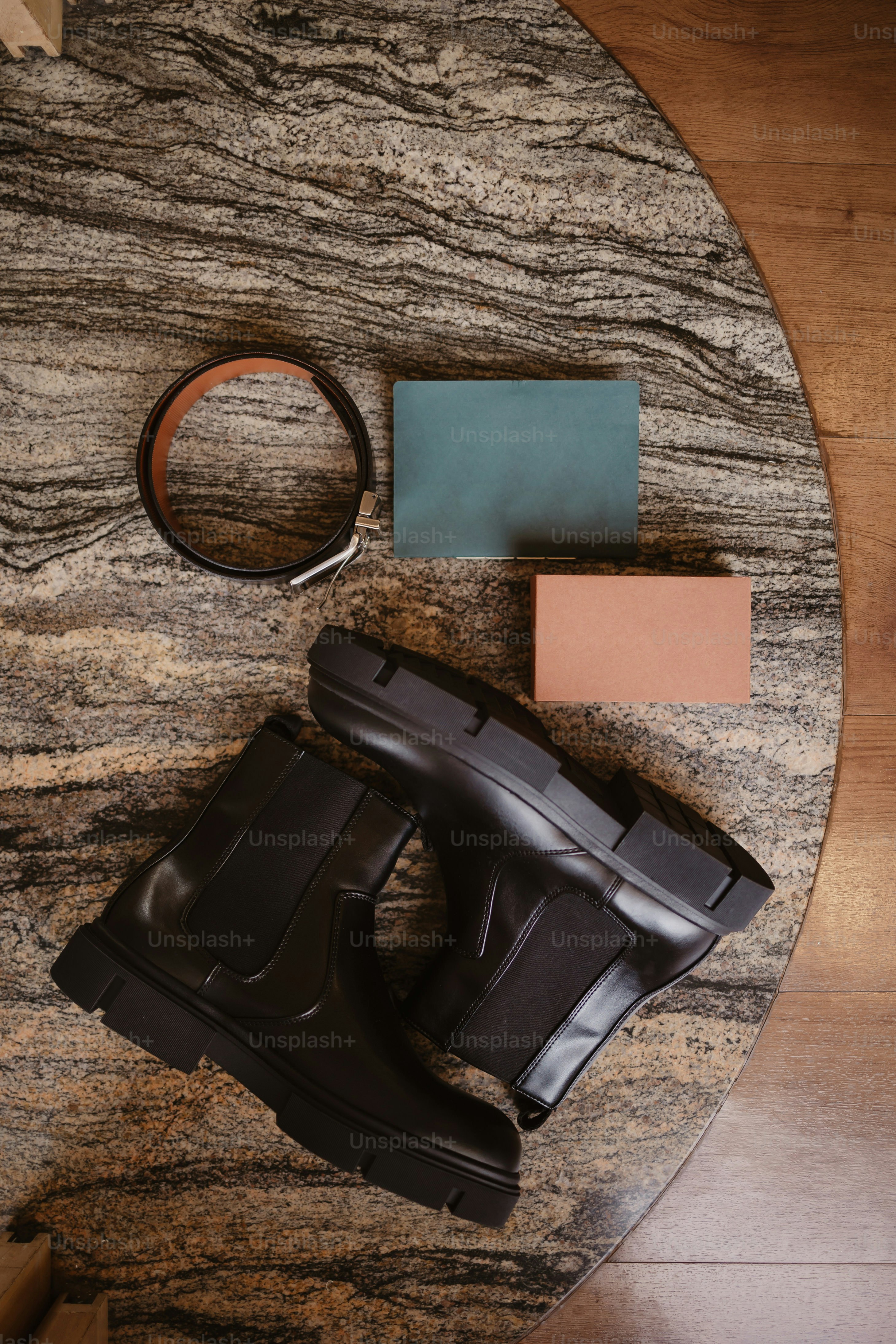 a pair of black rain boots, a wallet, and a pair of rubber boots