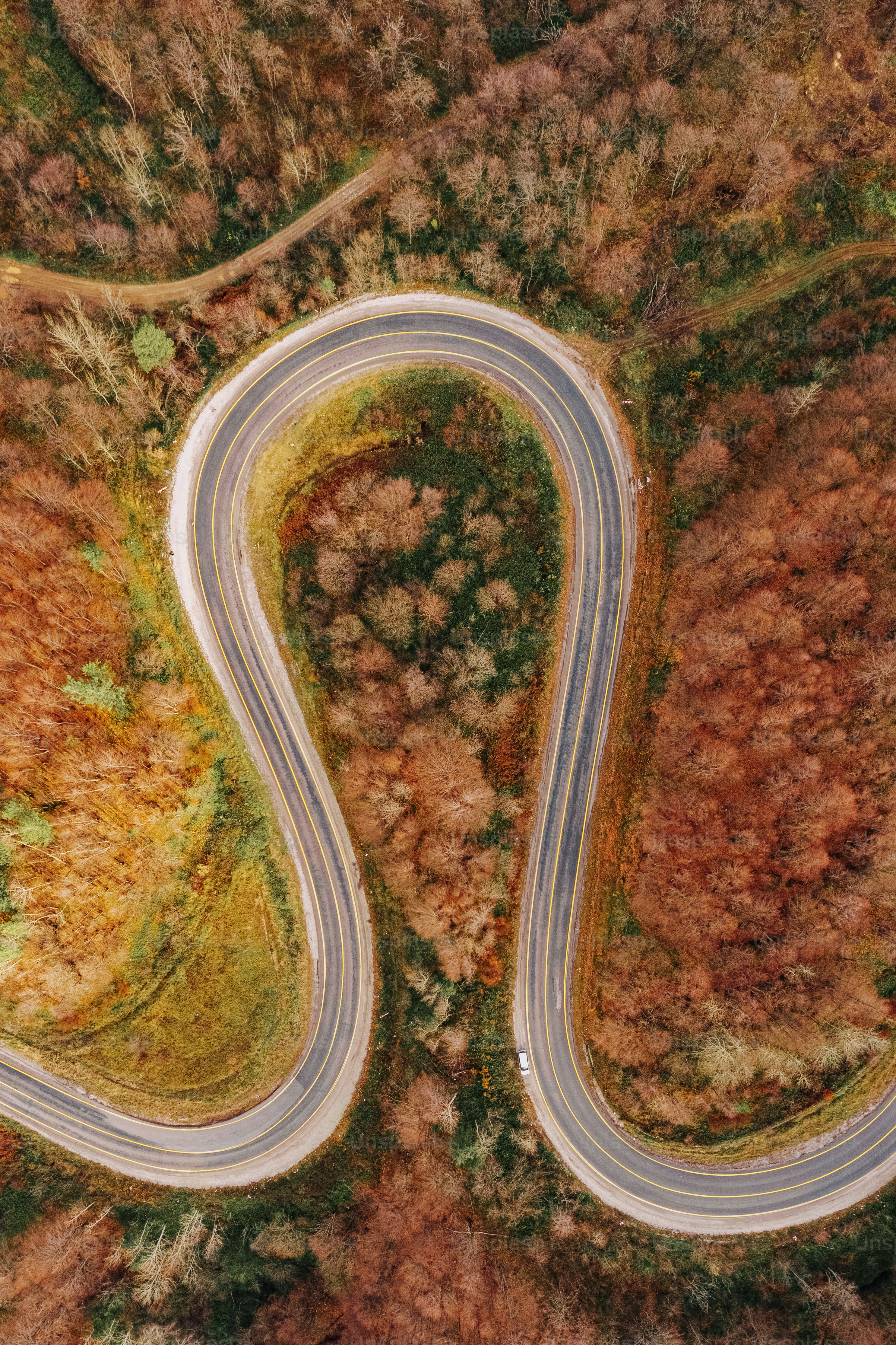 an aerial view of a winding road in the mountains
