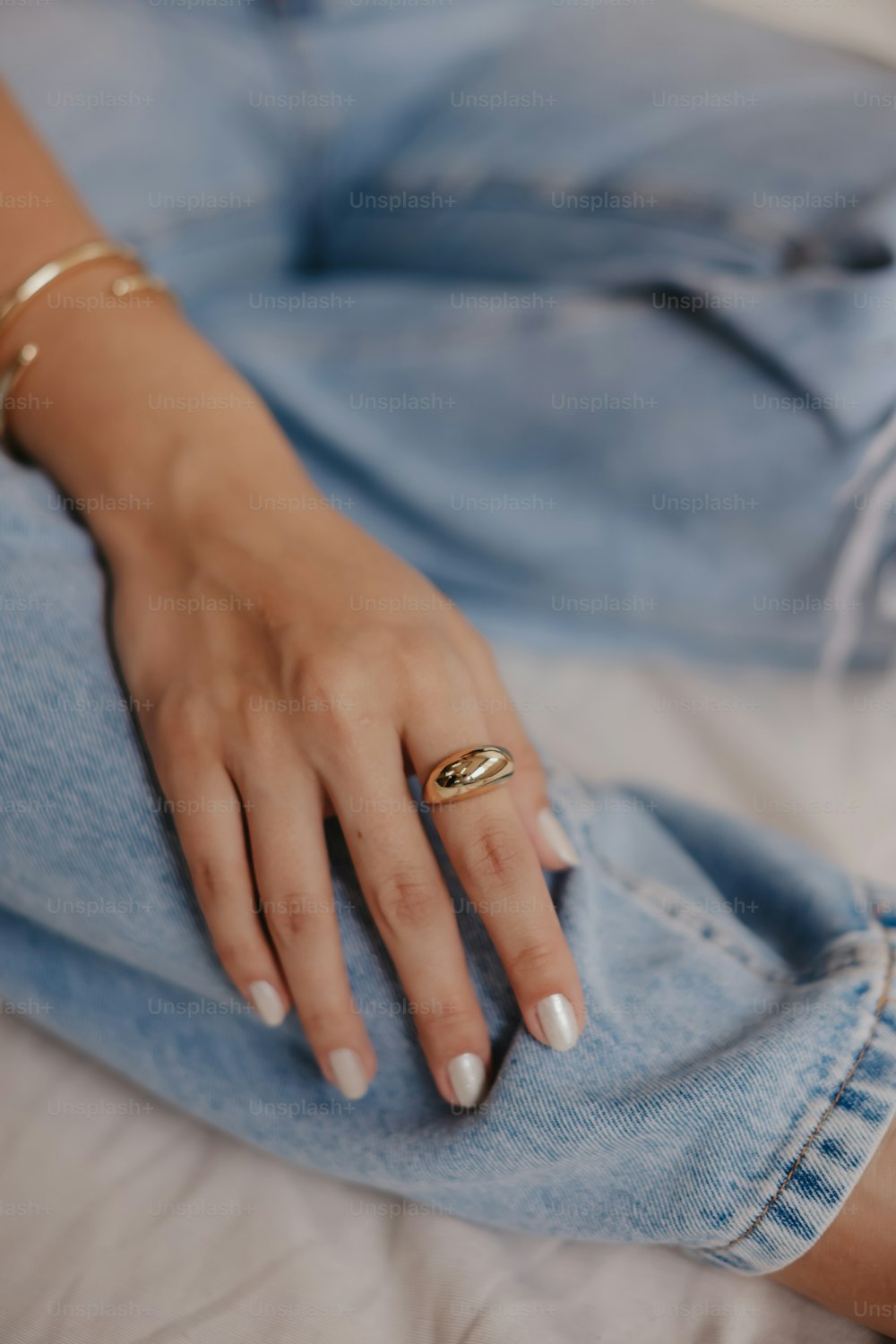a woman's hand resting on a pair of jeans