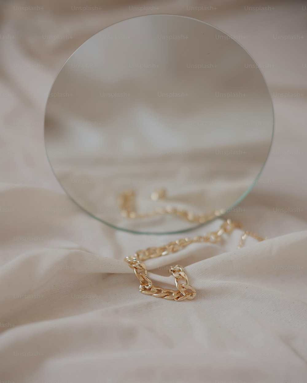 a mirror and a chain laying on a bed