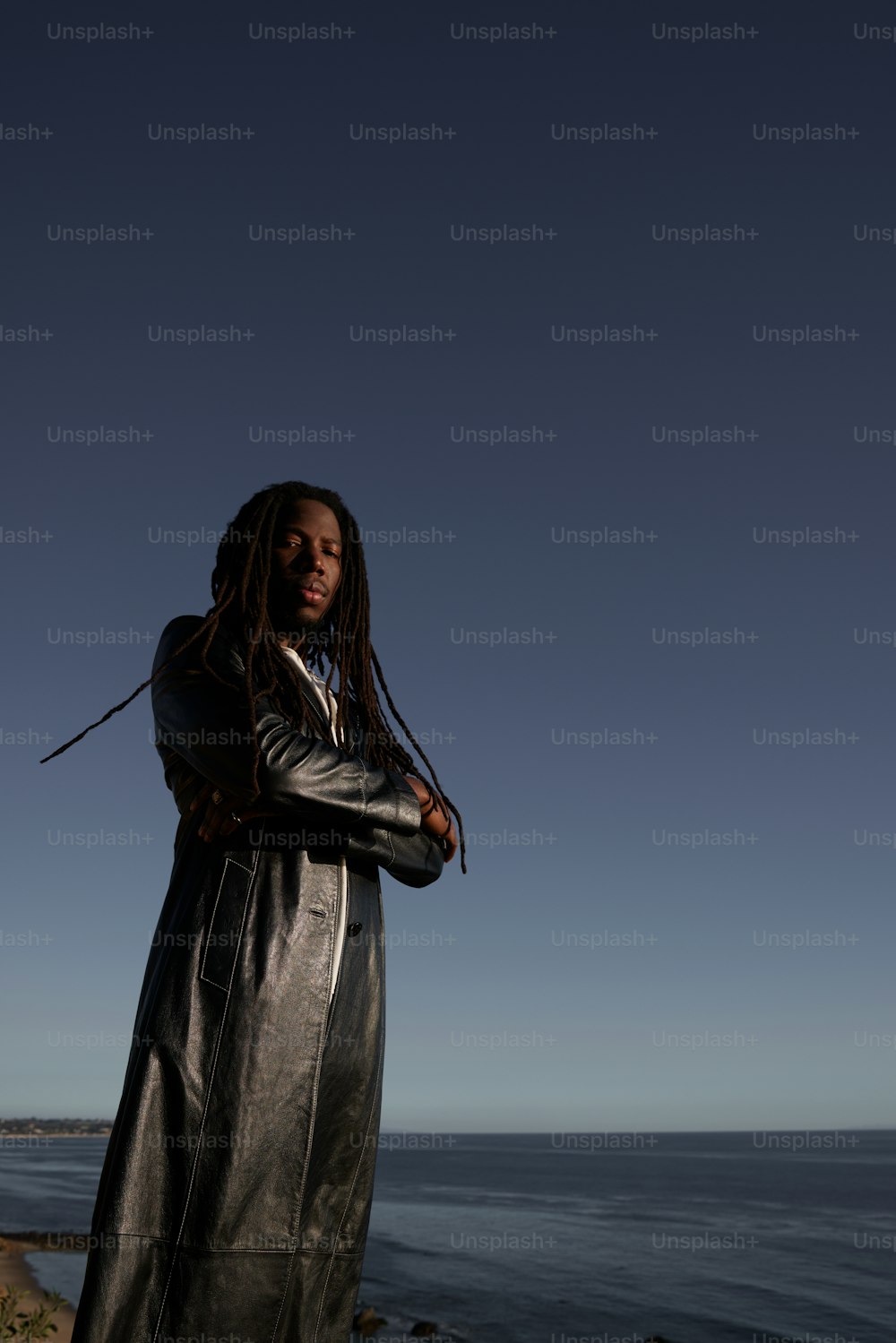a woman with dreadlocks standing by the ocean