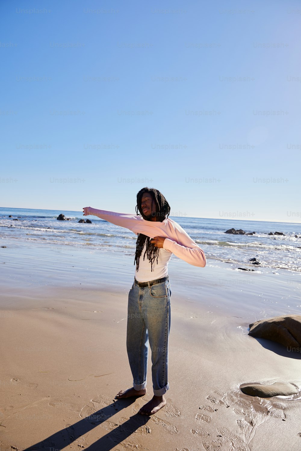 uma mulher em pé no topo de uma praia de areia