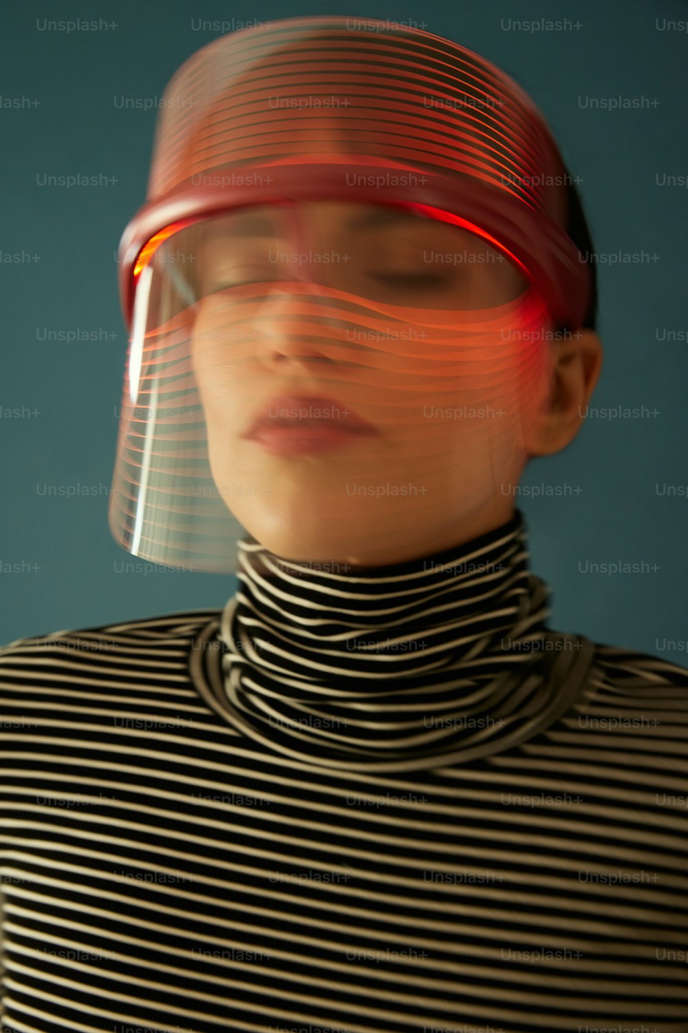a woman wearing a plastic hat and a striped shirt