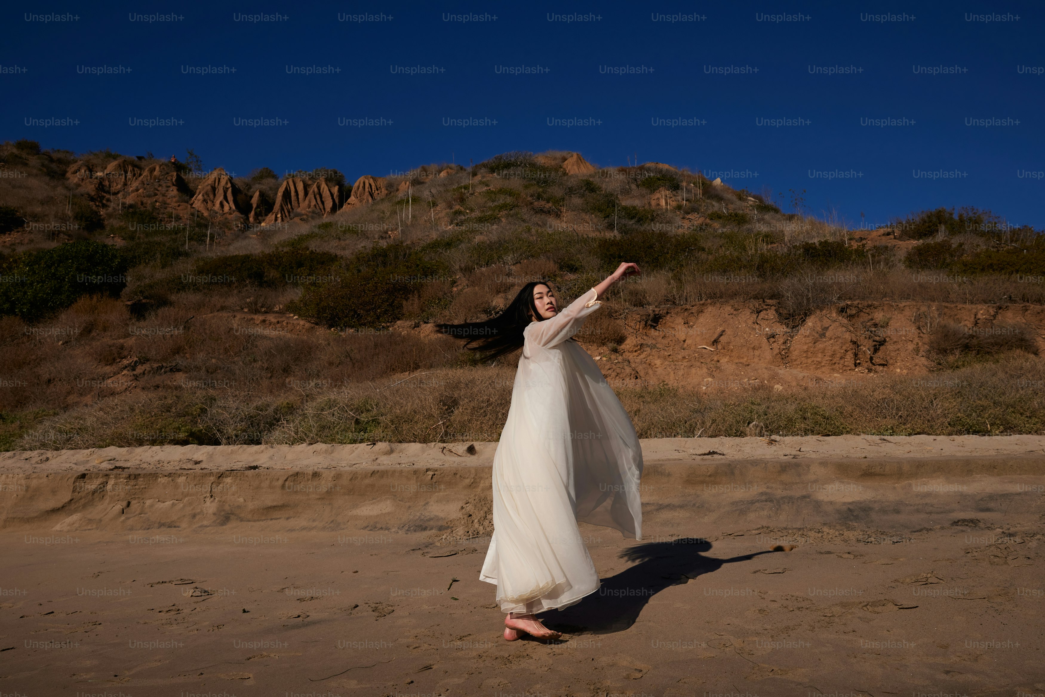 a woman in a white dress on a beach