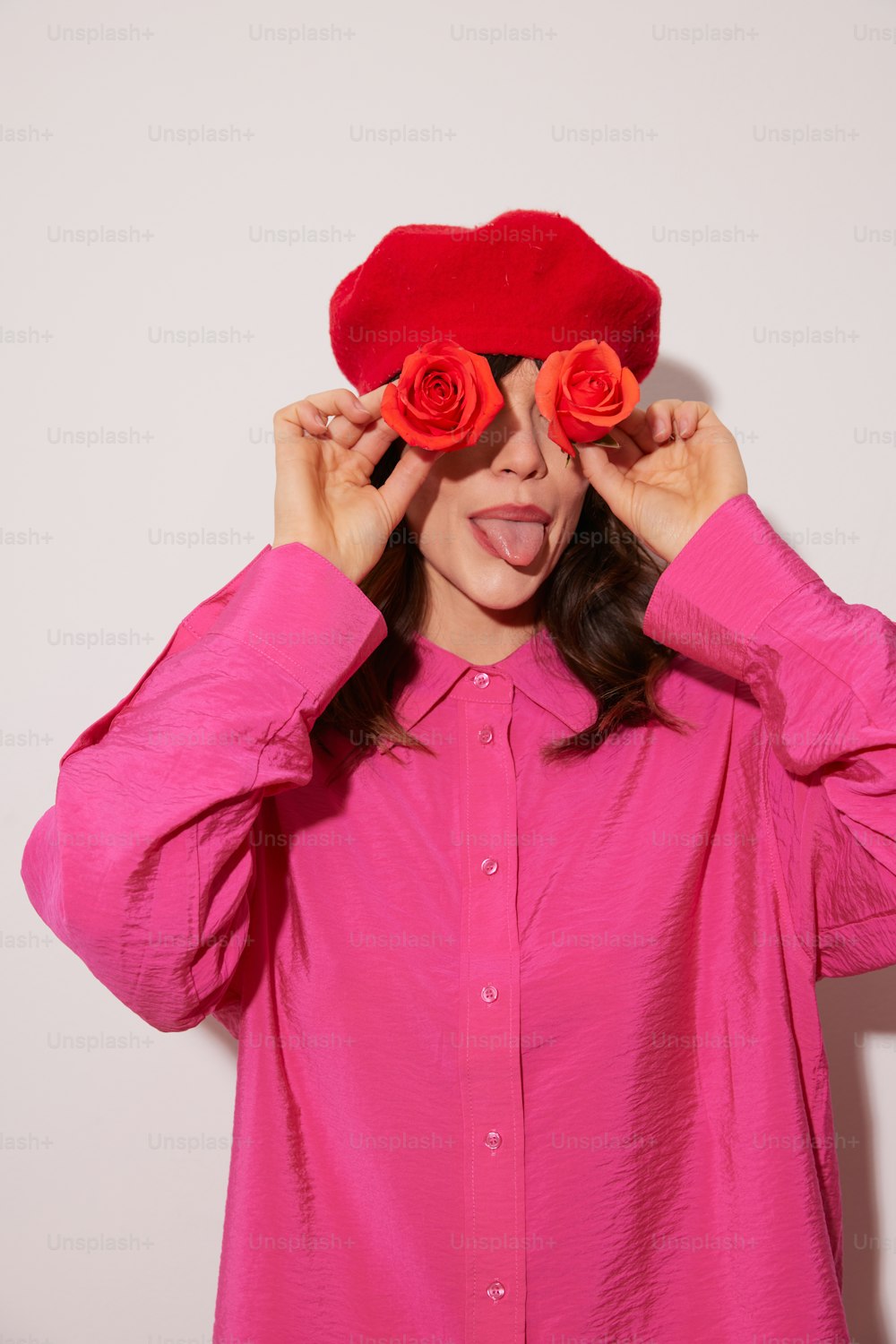 a woman wearing a pink shirt and a red rose hat