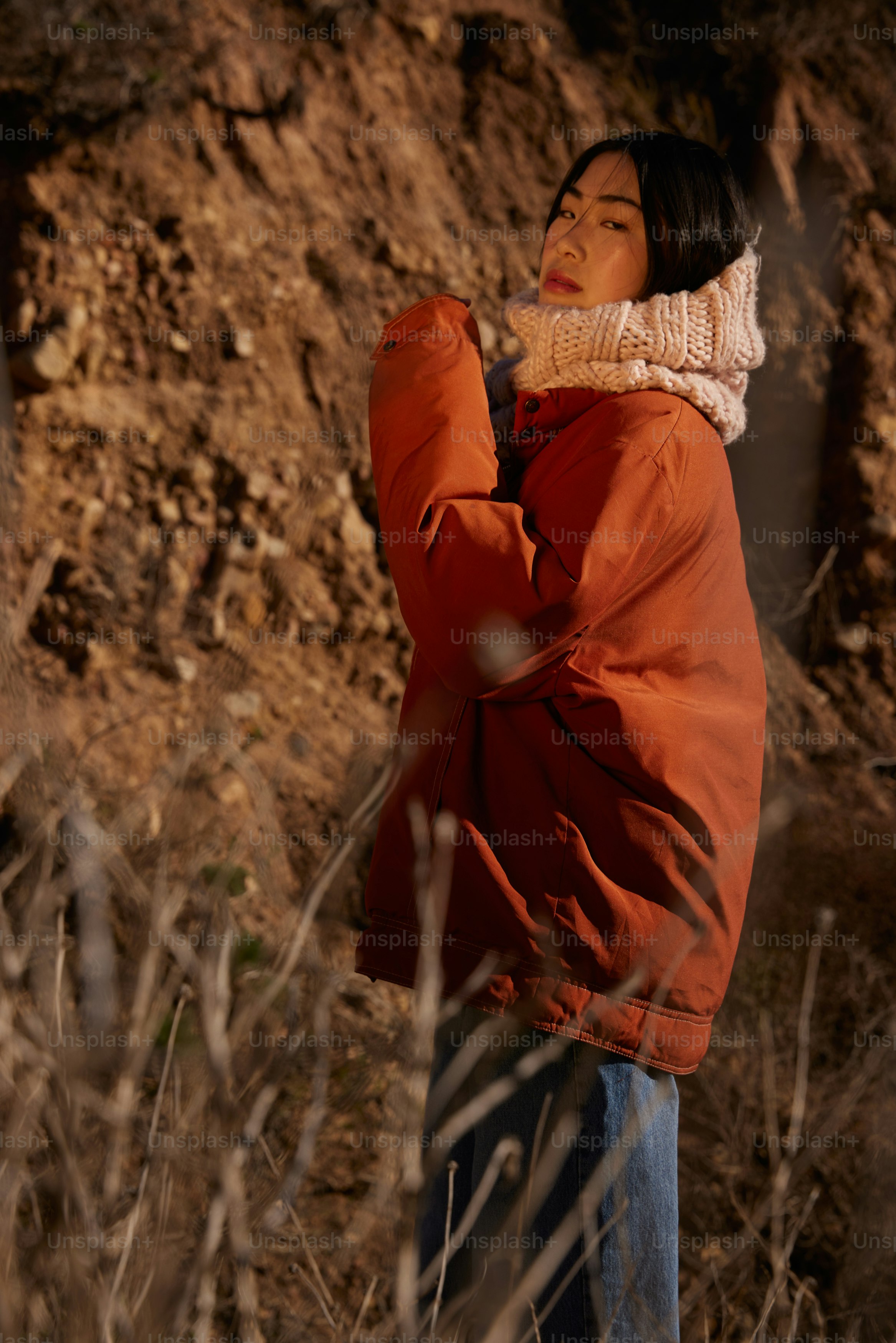 a woman in a red jacket standing in a field