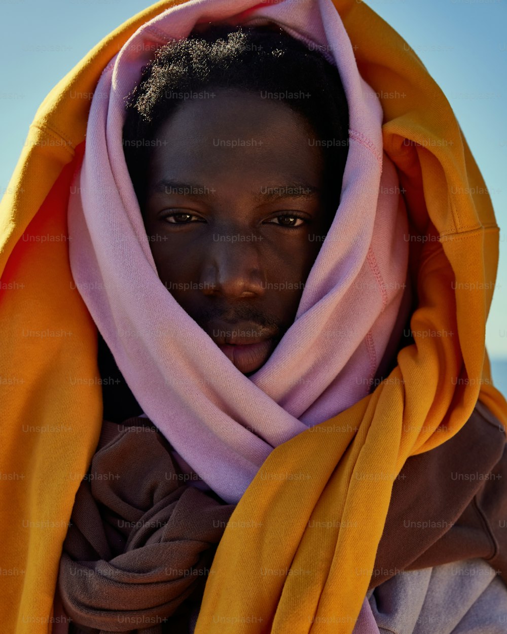 a woman with a yellow and pink scarf around her head