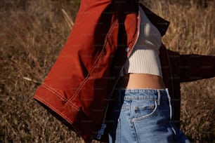 Una mujer con una chaqueta roja y jeans