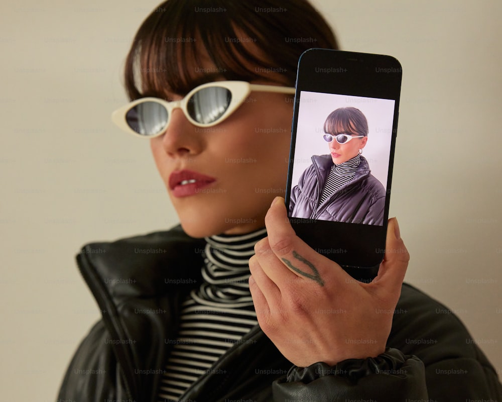 a woman holding up a cell phone with a picture on it