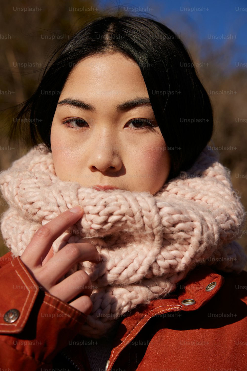 a woman wearing a red jacket and a pink scarf