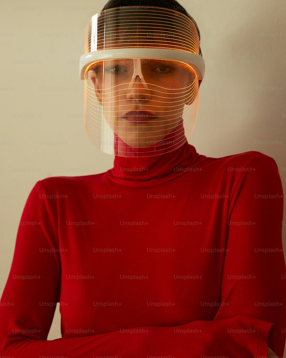 Eine Frau in einem roten Hemd mit einem Plastikkopf, der ihr Gesicht bedeckt