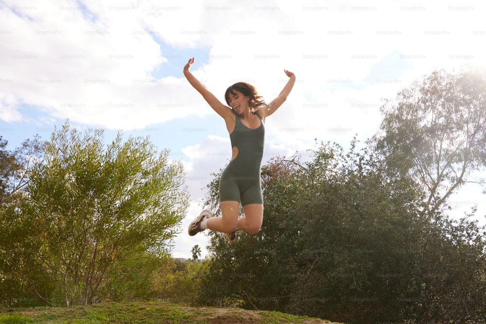 uma mulher pulando no ar com os braços estendidos