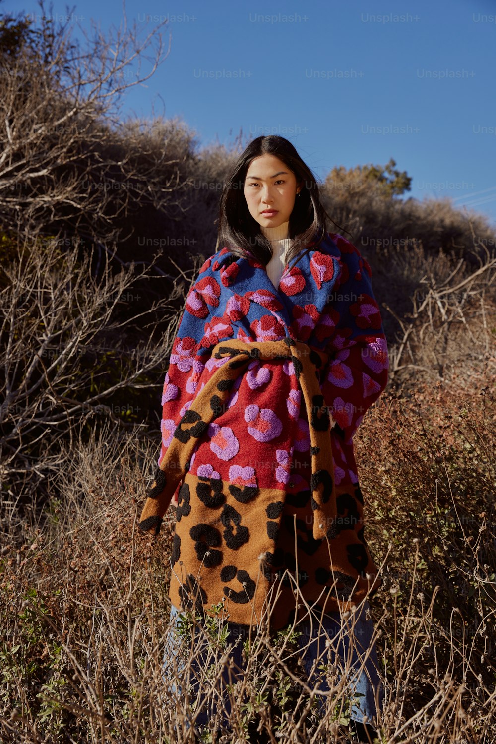 a woman standing in a field covered in a blanket