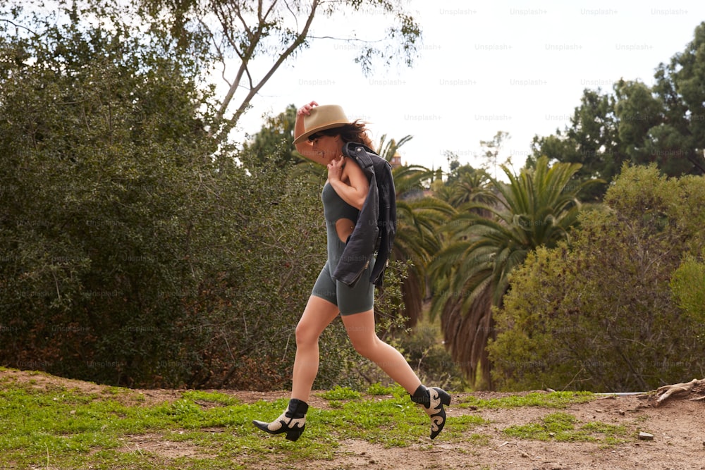 a woman wearing a hat and shorts is walking