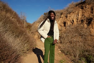 a man in a white jacket and green pants