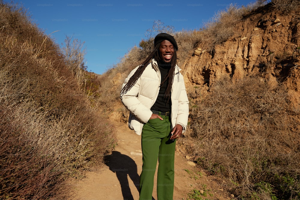 a man in a white jacket and green pants