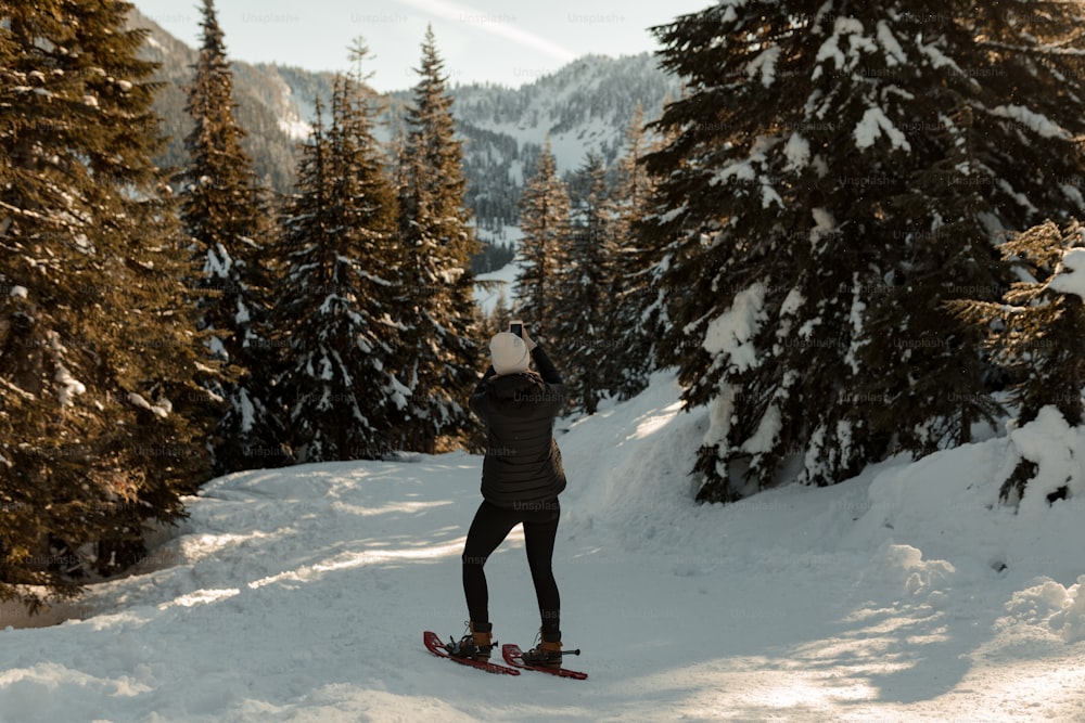 uma pessoa montando uma prancha de snowboard por uma encosta coberta de neve