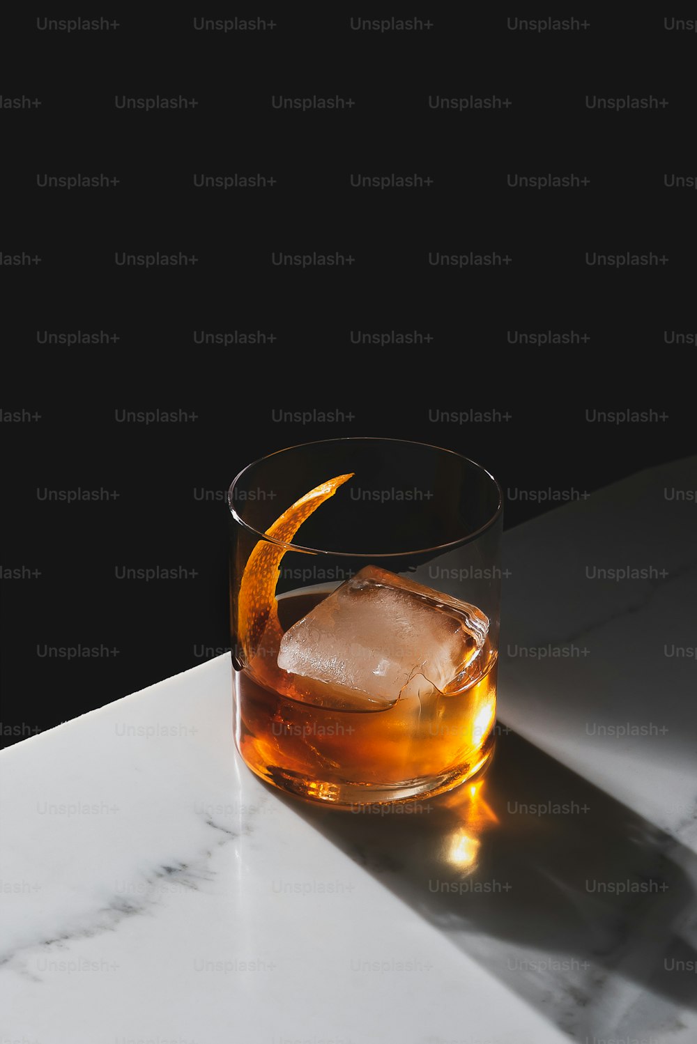 un bicchiere di whisky con una buccia d'arancia sul bordo