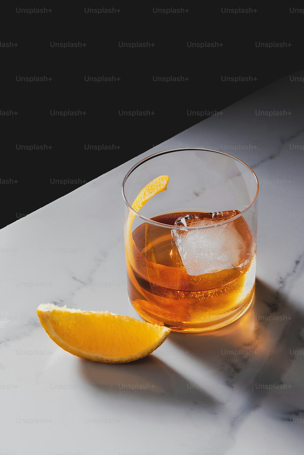 a glass of alcohol with a slice of orange