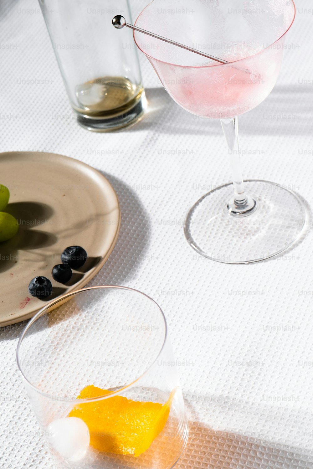 a glass of wine and a plate of grapes on a table