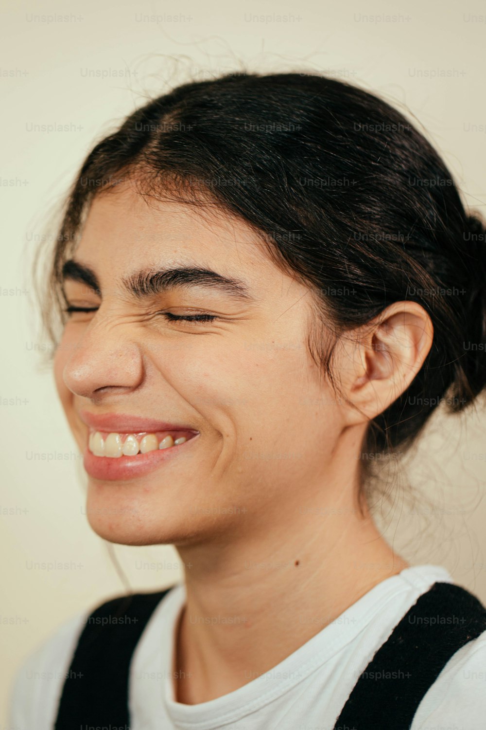 a woman smiling while holding a cell phone to her ear