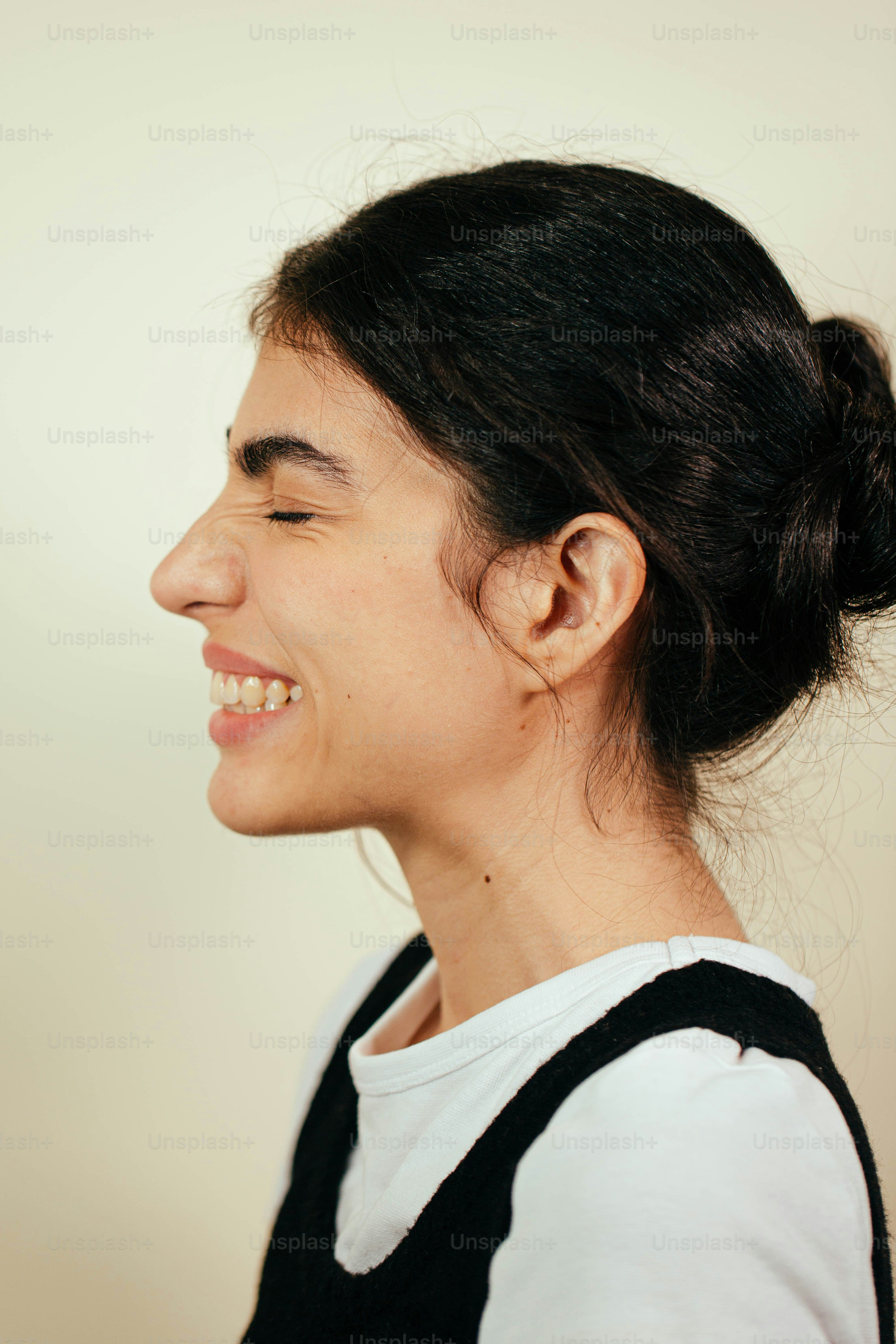 a woman smiling and holding a cell phone to her ear
