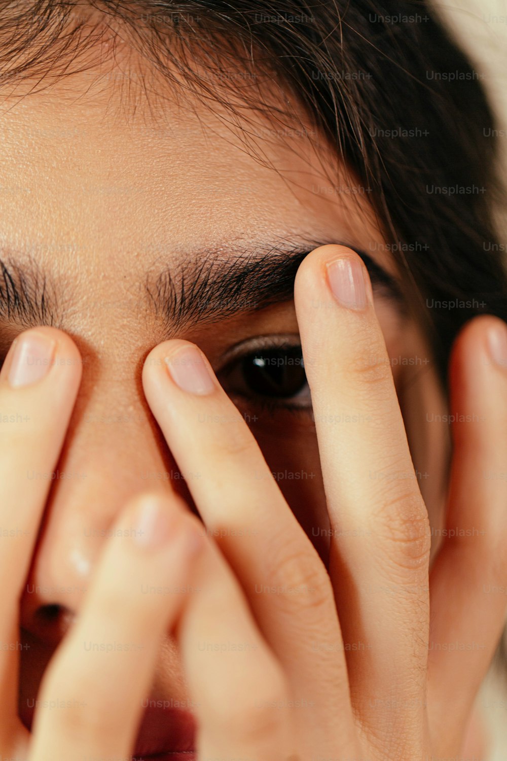 a close up of a person covering their eyes
