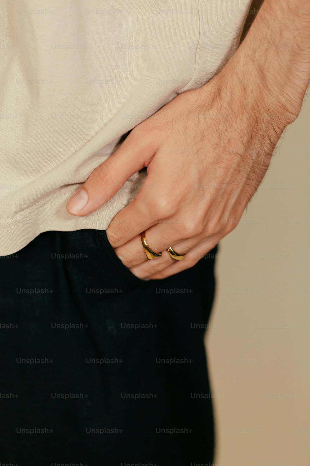 a man in a white shirt is wearing a gold ring
