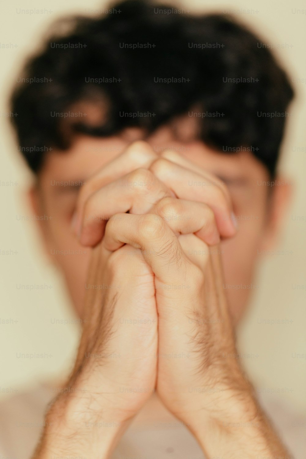 Un uomo che tiene le mani unite per pregare
